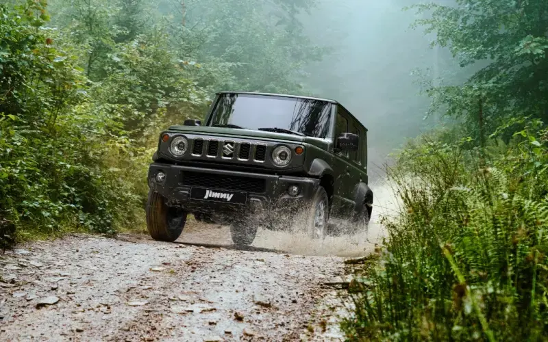 Suzuki Jimny todoterreno verde en acción, ideal para aventuras off-road.