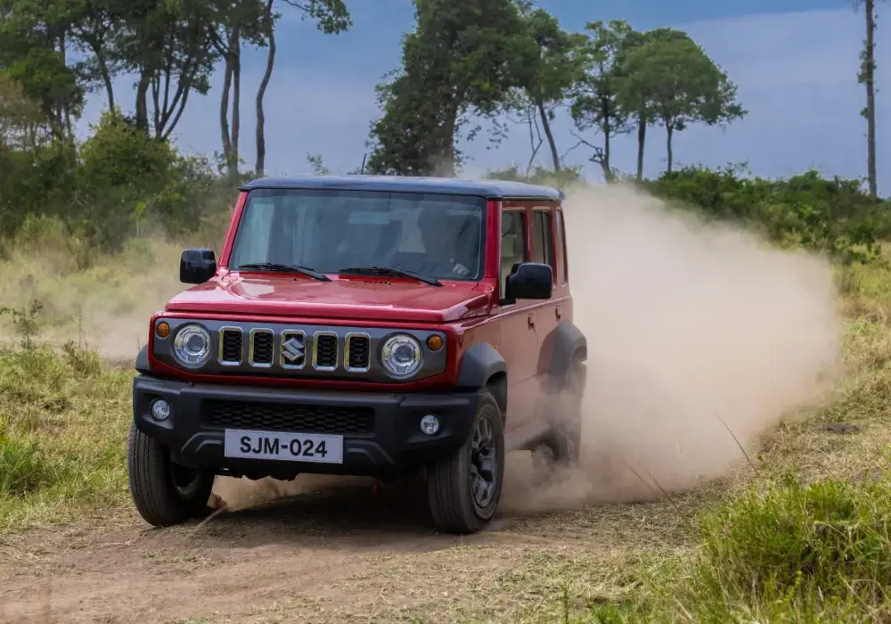 Suzuki Jimny de color rojo transitando por un camino de tierra