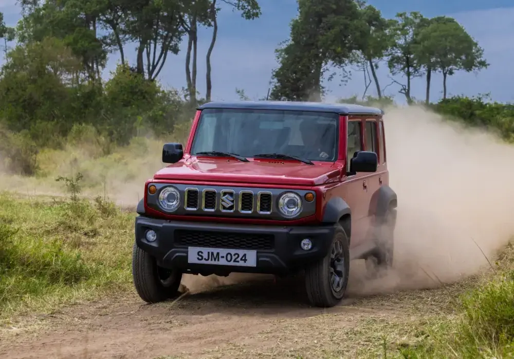 Suzuki Jimny rojo 5 puertas con techo negro y una franja negra.
